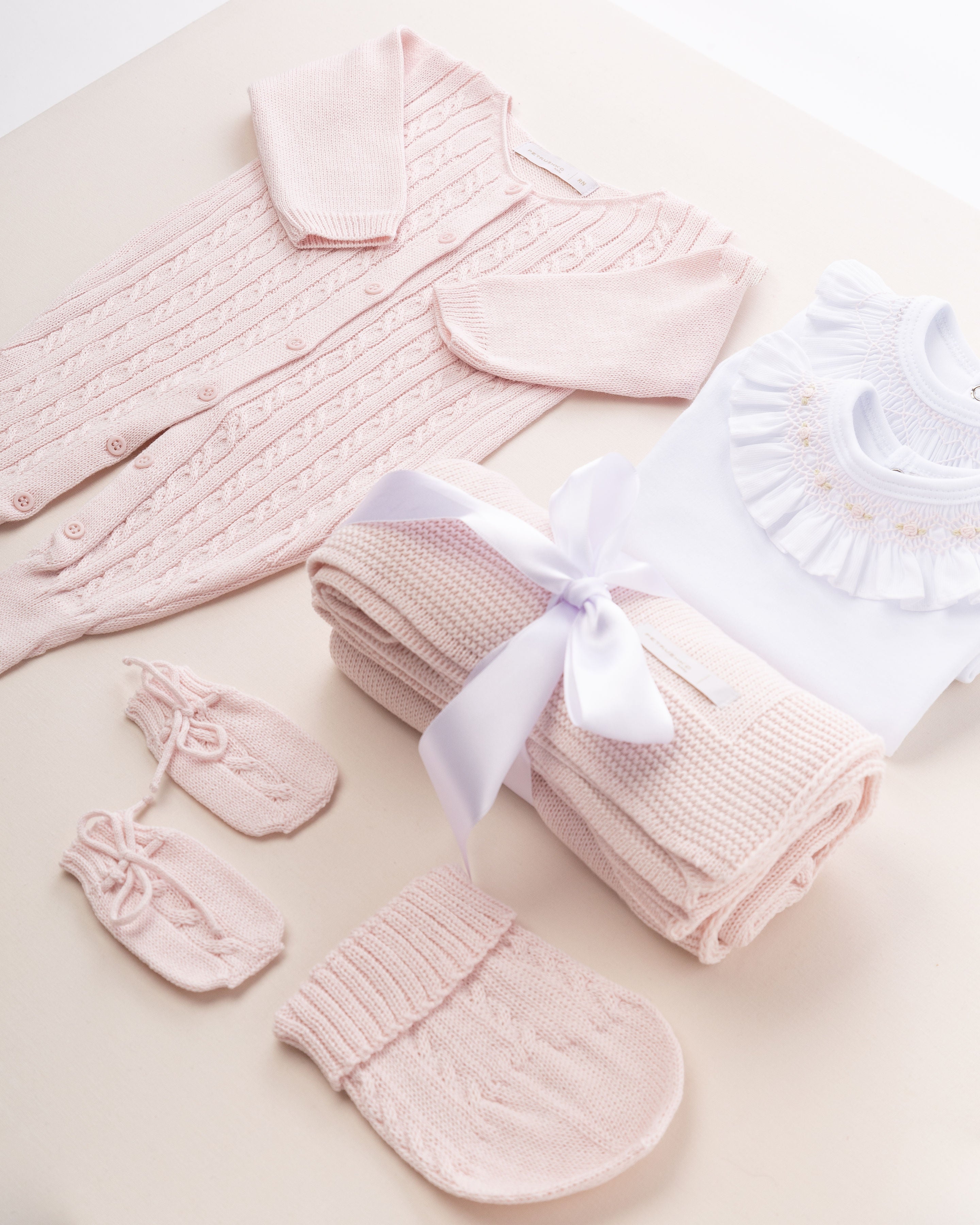 Nesta imagem, é possível explorar outros ângulos do kit de saída de maternidade. A tonalidade rosa é um clássico que traz harmonia e suavidade para o visual da bebê.