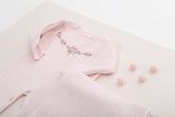 Nesta imagem, é possível explorar outros ângulos do kit de saída de maternidade. A cor rosa é um clássico que traz harmonia e suavidade para o visual da bebê.
