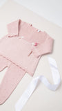 Na imagem, é possível ver detalhes encantadores do conjunto de calça e blusa na cor rosa. 